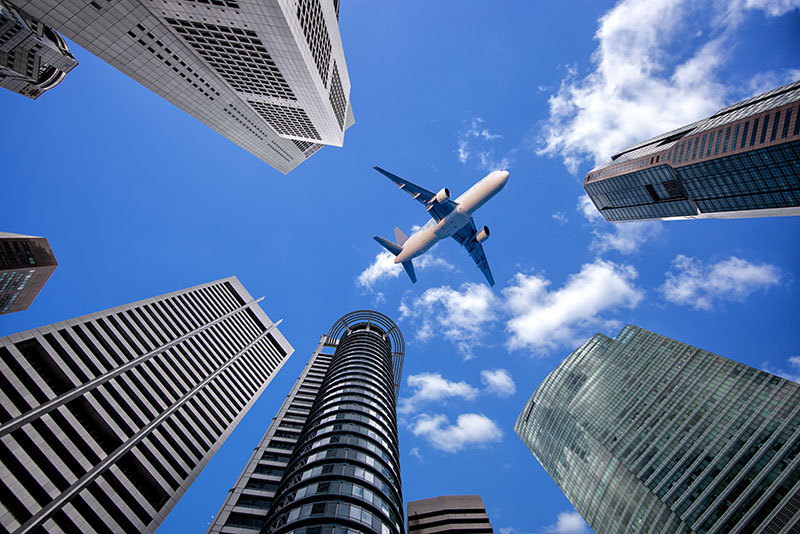 Airplane flying between skyscapers