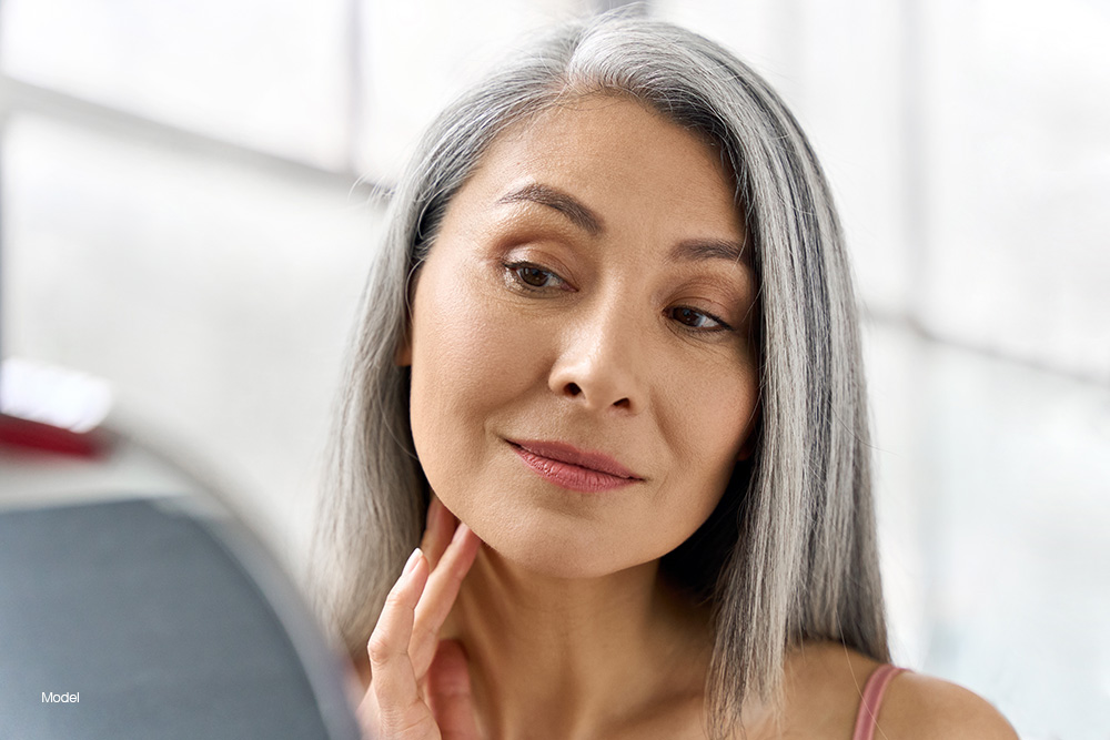 Mature woman looking at herself in the mirror